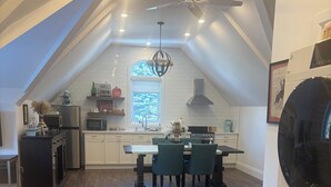 A kitchen with a dining area, wooden flooring, a ceiling fan, and a washing machine. - Newly renovated 1 Bedroom apartment in Alton, Ontario (Alton)