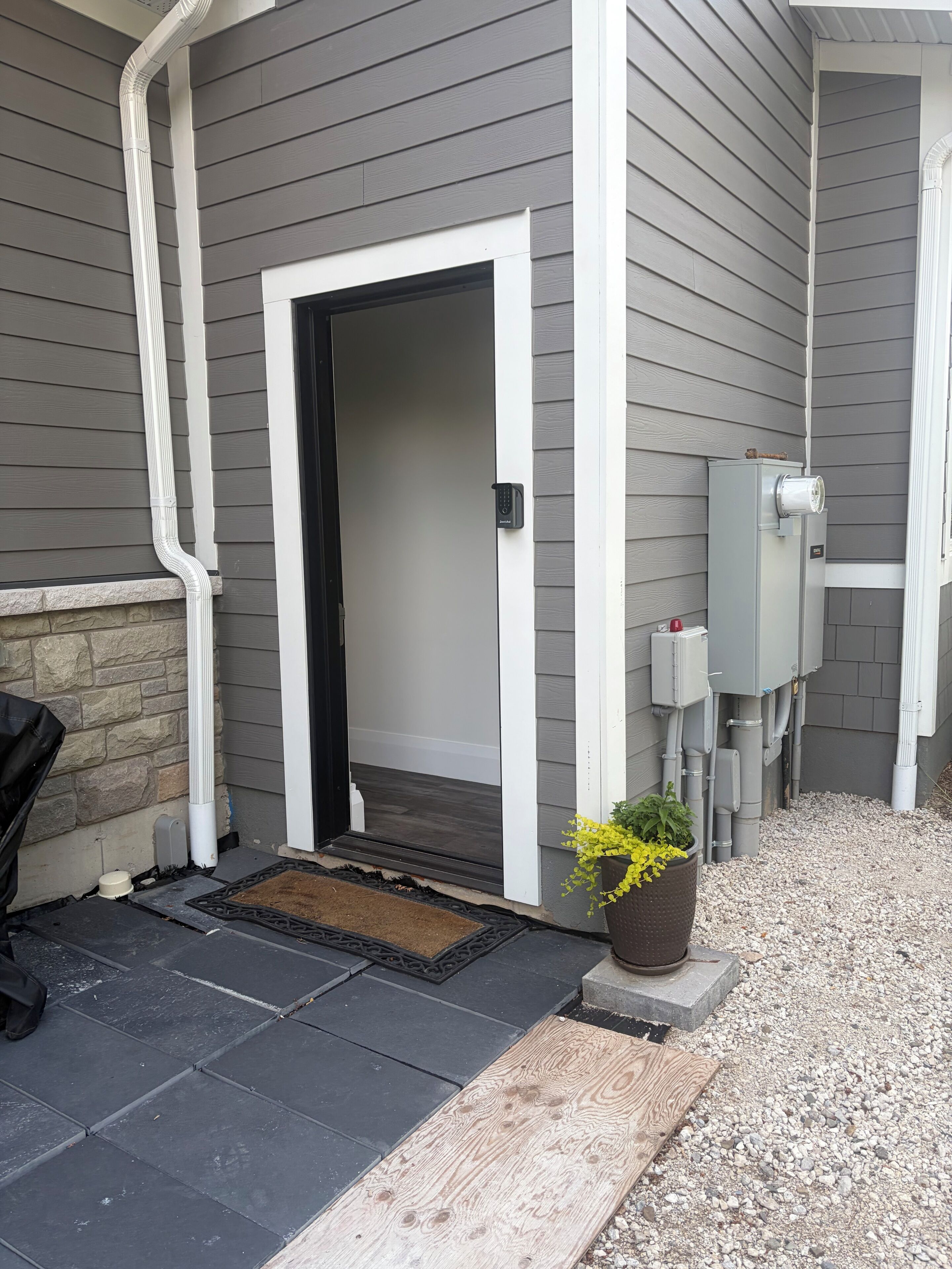 A house entrance with a door, a mailbox, and a utility box.