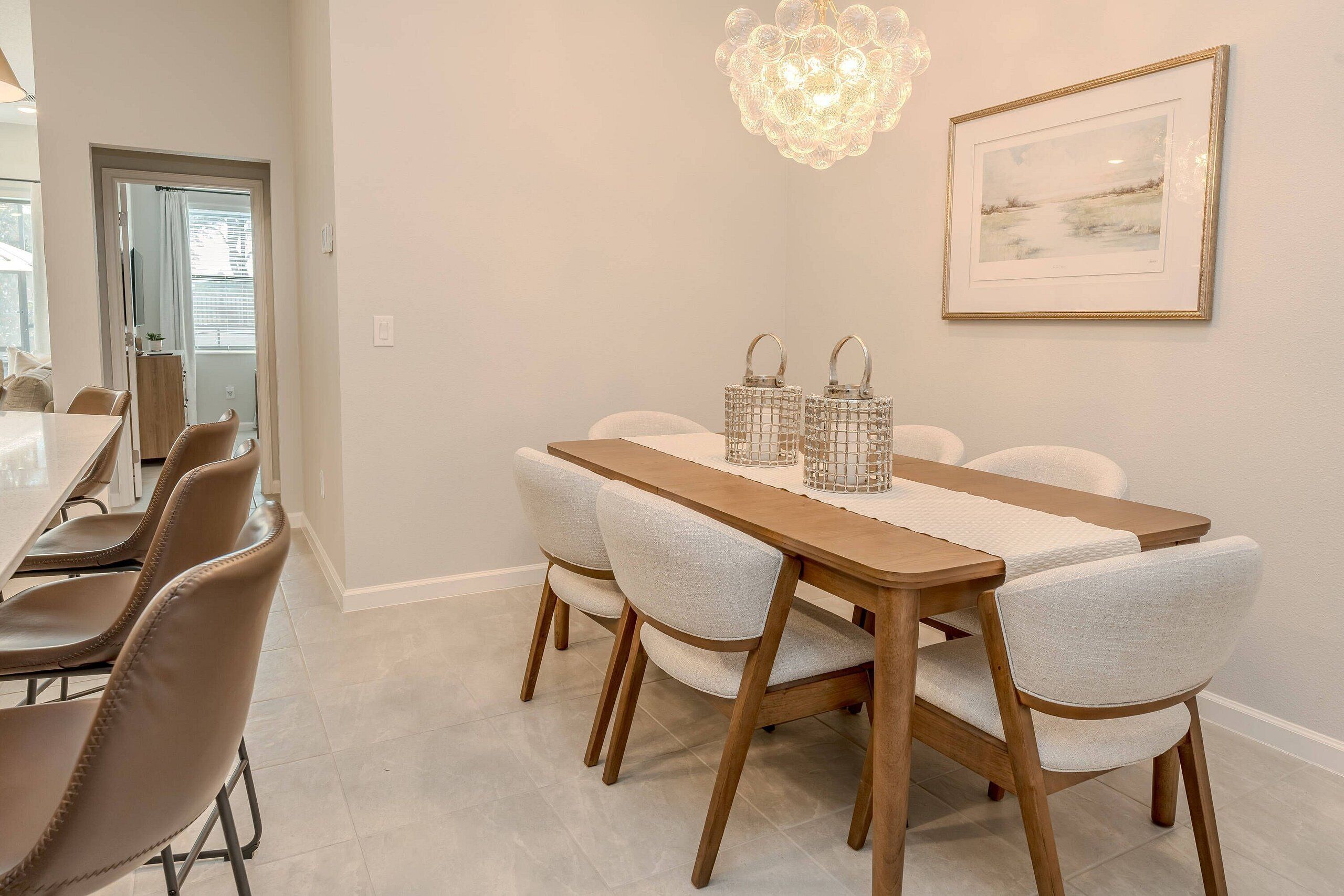 A dining area with a wooden table, four chairs, and two lanterns.