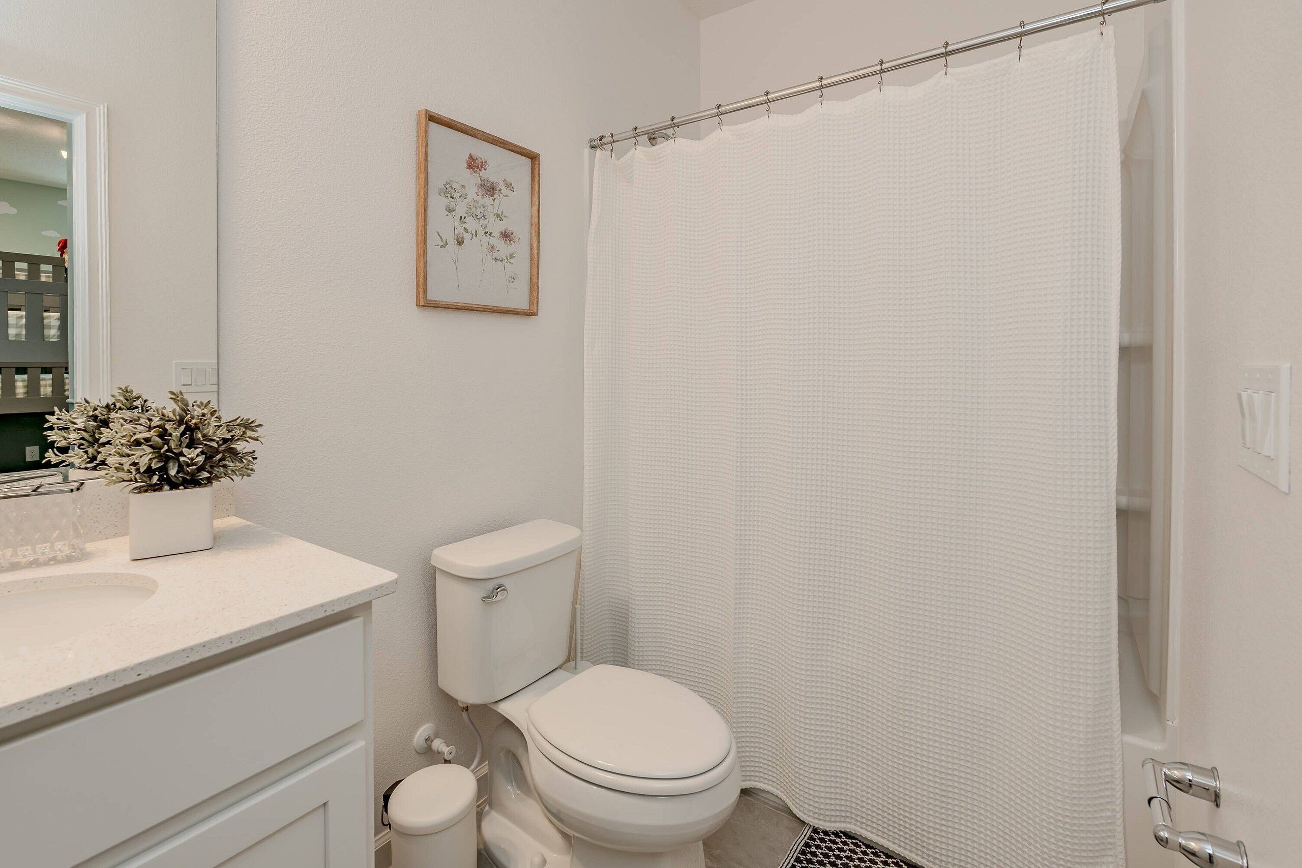 A bathroom with a toilet, sink, and shower curtain.