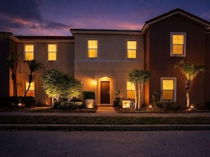 A two-story building with a central entrance, multiple windows, and a well-lit facade. - Spacious 3BR Townhome with Private Pool in Bella Vida, Kissimmee (Kissimmee)
