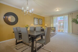 A dining area with a round mirror, chandelier, and two framed pictures on the wall. - Spacious 3BR Townhouse in Vista Cay – Sleeps 8 Near Disney (Orlando)