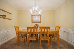 A dining room with a wooden table and chairs, a chandelier, a framed picture on the wall, and a flower vase. - Spacious 3BR/2BA Apartment at Vista Cay, Minutes from Disney & Universal (Orlando)