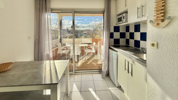 Eine moderne Küche mit Bergblick, ein Essbereich mit Tisch und Stühlen sowie ein Balkon mit Aussicht.