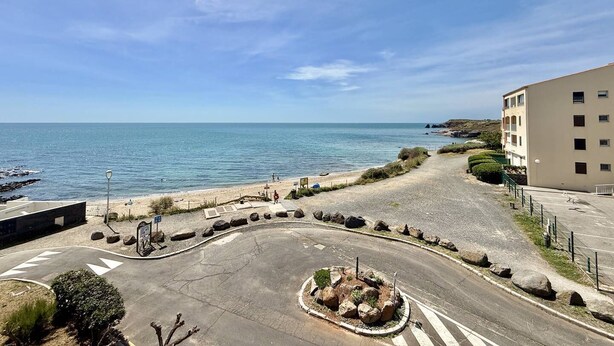 Una carretera costera con una glorieta, una playa y un edificio de varios pisos.