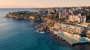A coastal hotel with a pool, multiple floors, and a view of the sea. - BONDI SALT & SURF 3 bedroom apartment with Parking (Bondi Beach)
