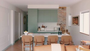A compact kitchen with a central island, a dining area with chairs, and a visible brick wall. - BONDI SALT & SURF 3 bedroom apartment with Parking (Bondi Beach)