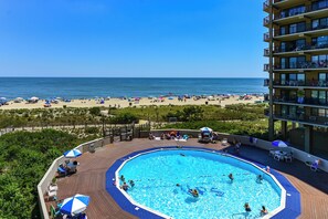 Ein Pool auf dem Dach mit Blick auf Strand und Meer.