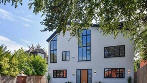 A modern two-story house with a large front lawn and a brick entrance. - Glams Beautiful Luxury Home (Wolverhampton)