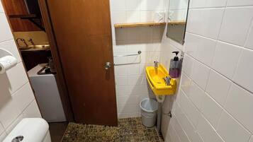 A small bathroom with a toilet, sink, and mirror.