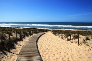 A wooden boardwalk leading to a sandy beach with ocean views. - Les trois chênes - BISCARROSSE (BISCARROSSE)
