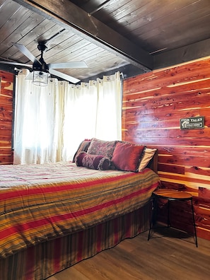Une pièce confortable avec un lit, une petite table et un panneau accroché au mur.