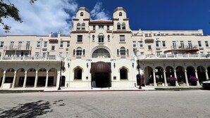 A large, historic building with a central entrance, multiple balconies, and a courtyard with potted plants. - The Green Room - Serene Poolview Studio with Parking Spot and 24x7 Front Desk (Palm Beach)