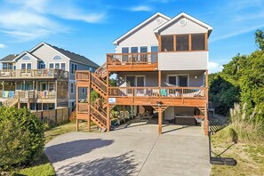 Ein zweistöckiges Gebäude mit Balkon, Treppe und Garage.