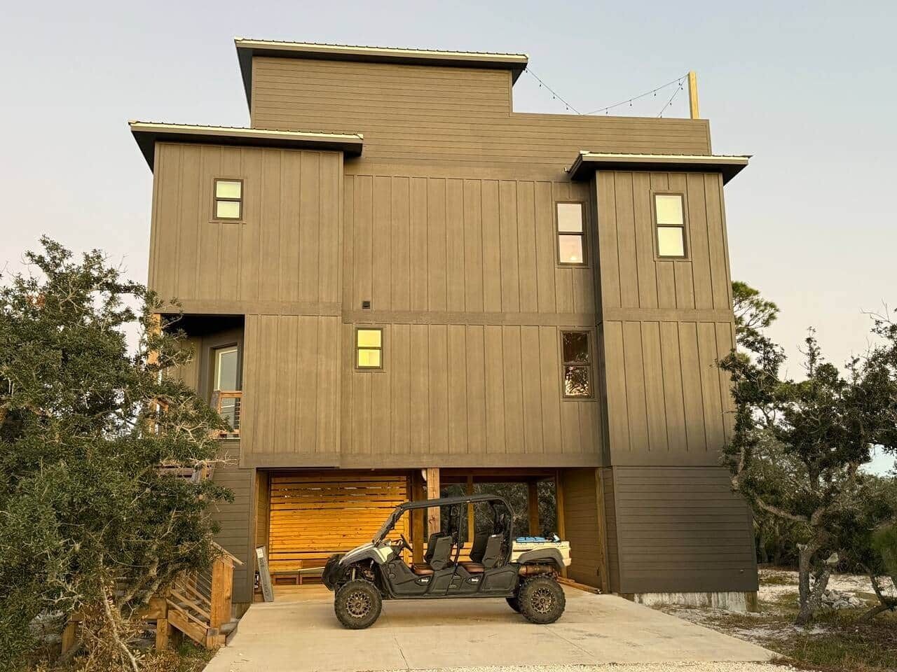 A modern two-story house with a garage and a vehicle parked in front.