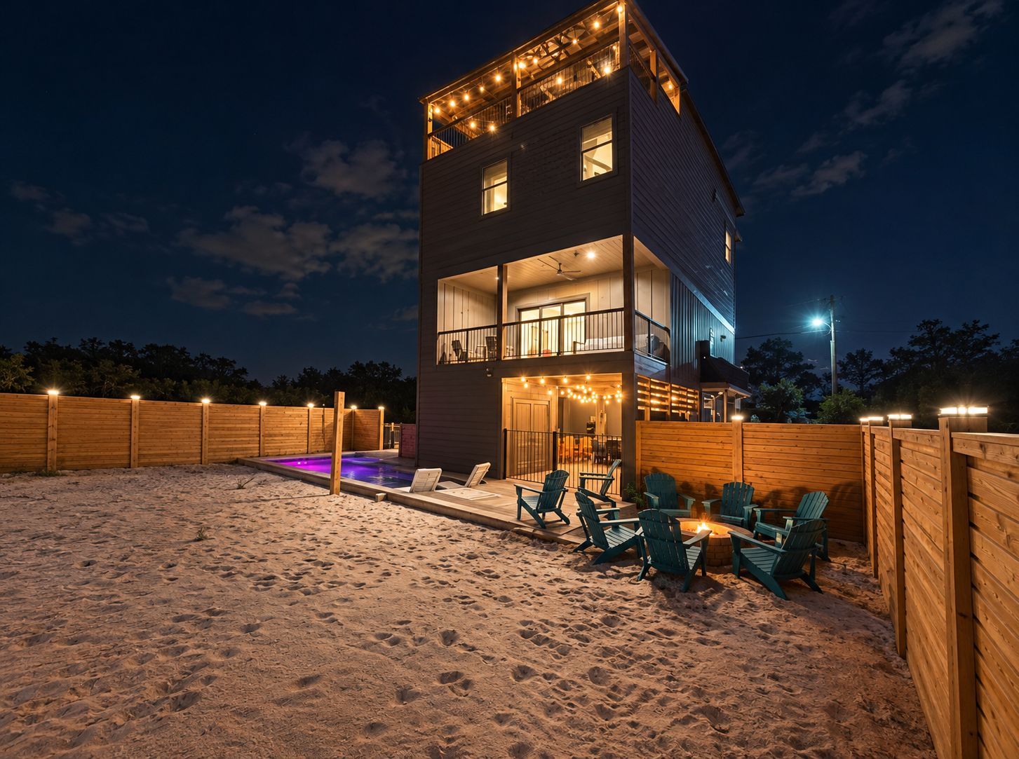 Un edificio de dos pisos con balcón, piscina y mobiliario para exteriores.