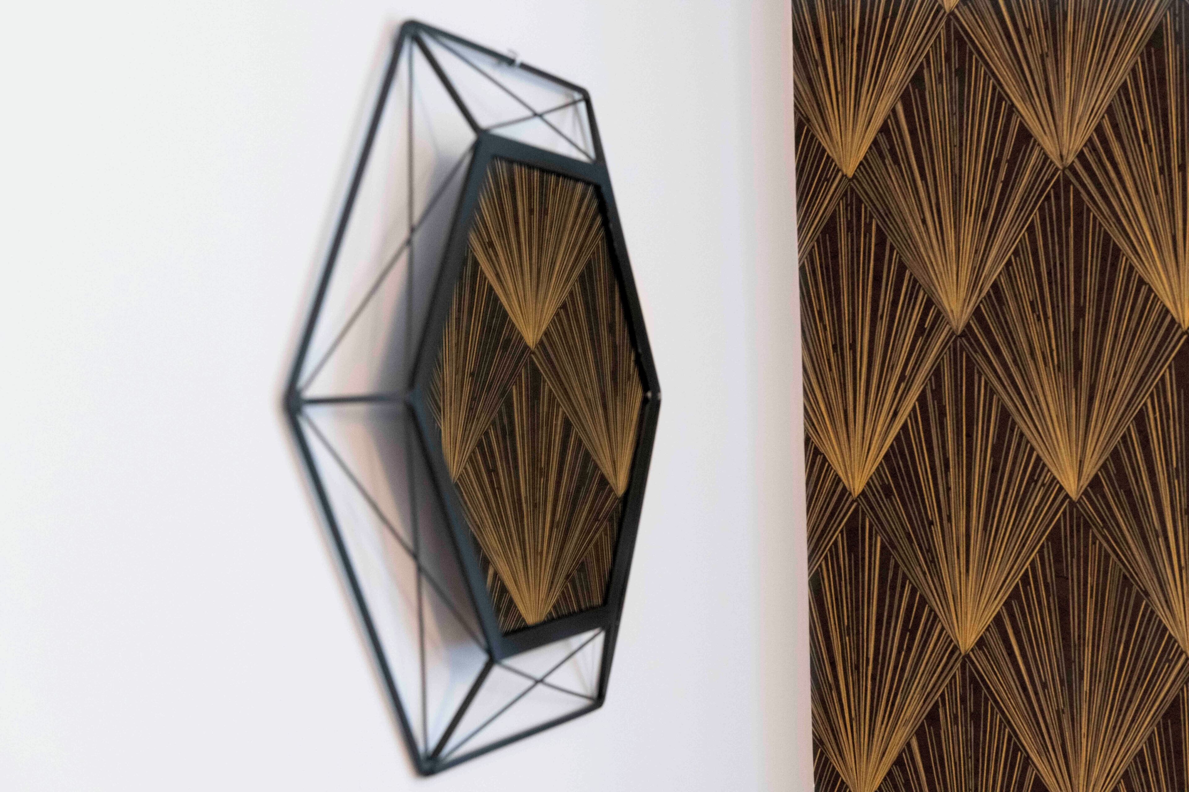 Un'opera d'arte geometrica per la parete, con un disegno esagonale centrale e carta da parati a motivi a diamante.