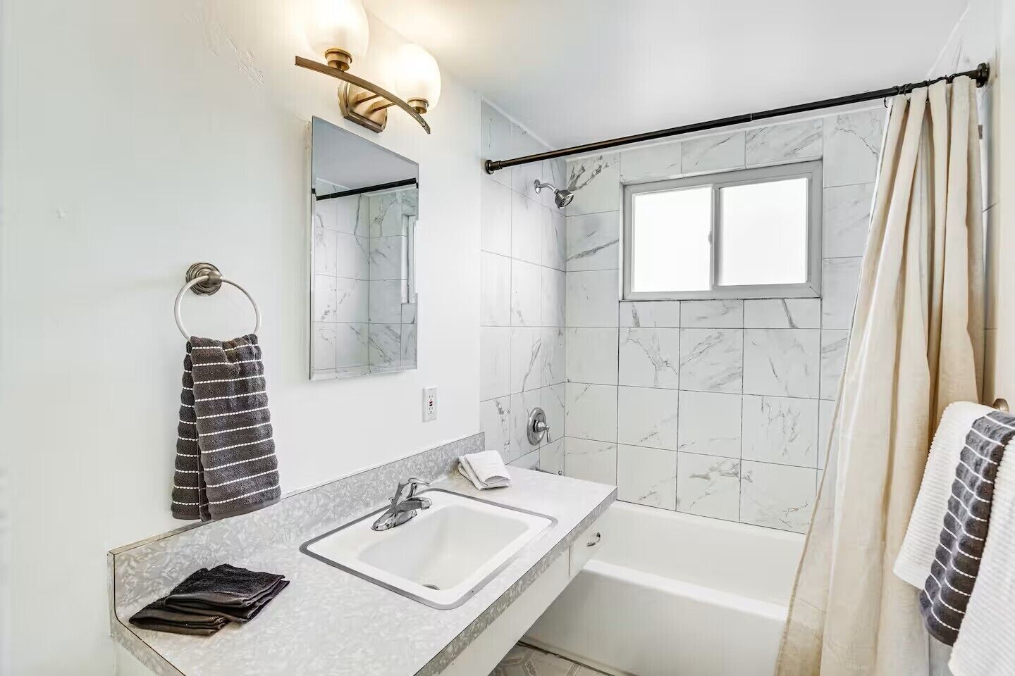 A modern bathroom with two sinks, a bathtub, and a shower.