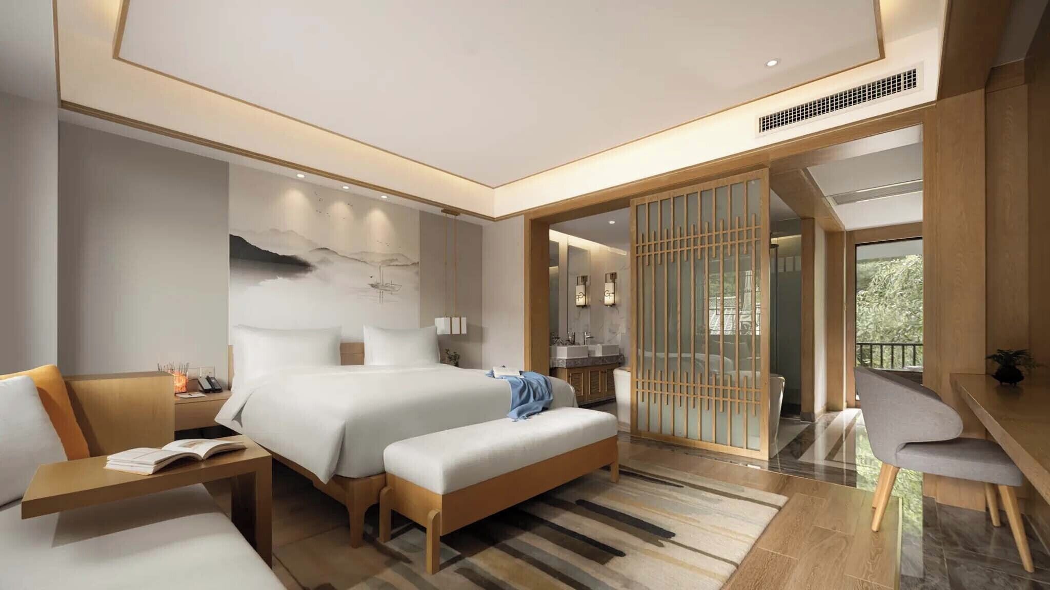 A modern hotel room with a large bed, bedside tables, a desk, and a balcony with a view.