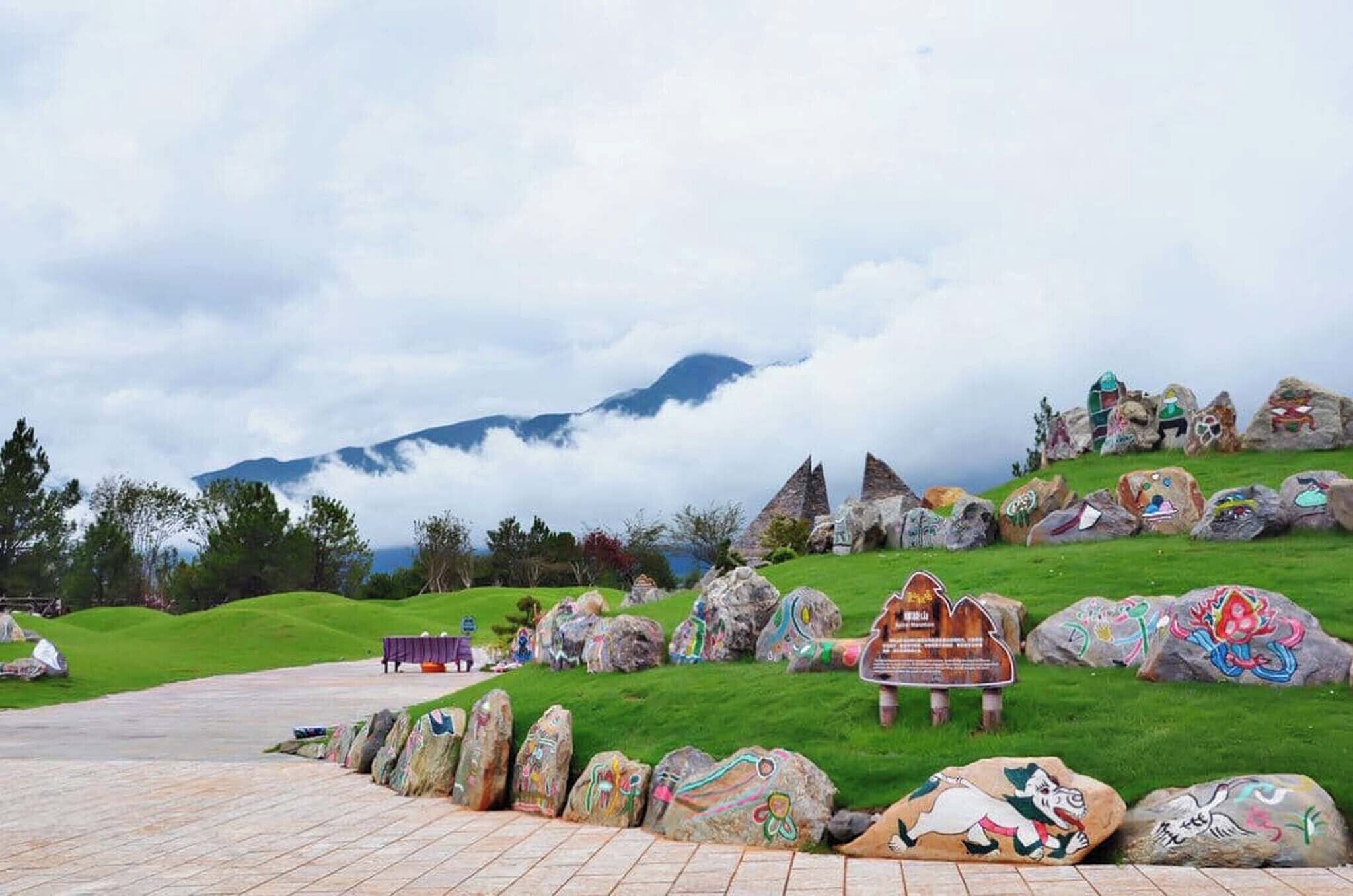 A grassy area with large rocks and a signboard.