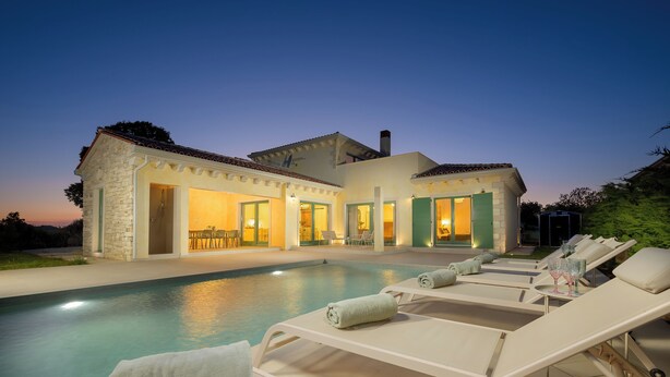 A modern villa with a swimming pool, lounge chairs, and a well-lit outdoor seating area. - Villa Kaia (Istria - Kringa) (Kringa)