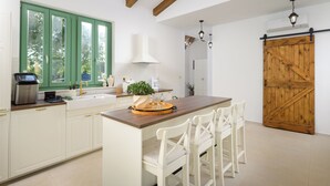 A kitchen with white cabinets, a wooden island, and a sliding barn door. - Villa Kaia (Istria - Kringa) (Kringa)