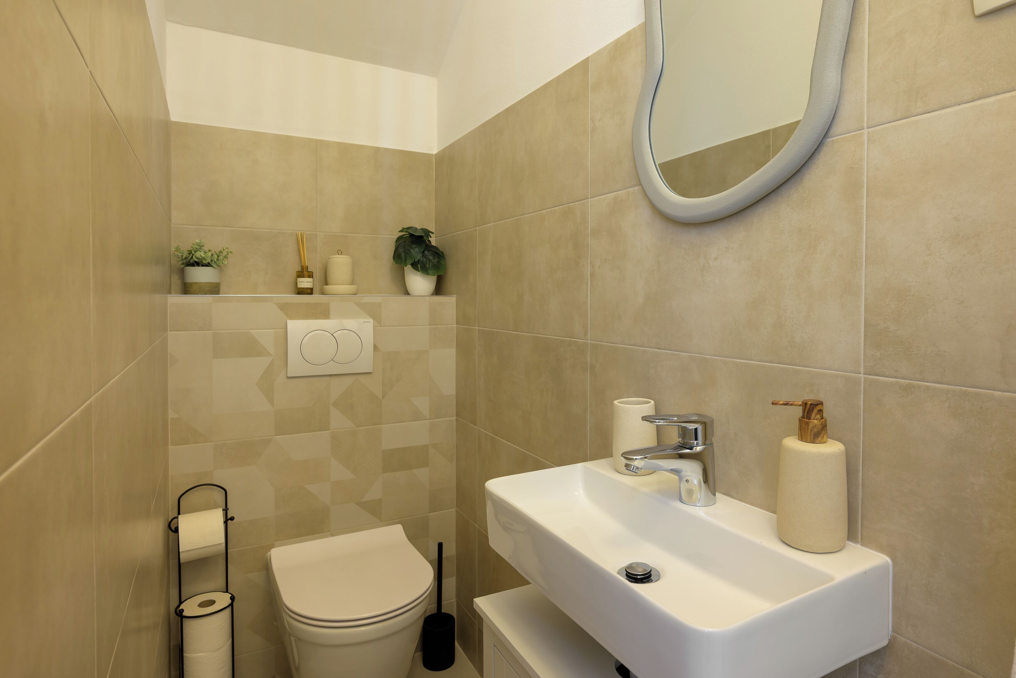 A bathroom with a toilet, sink, mirror, and towel rack.