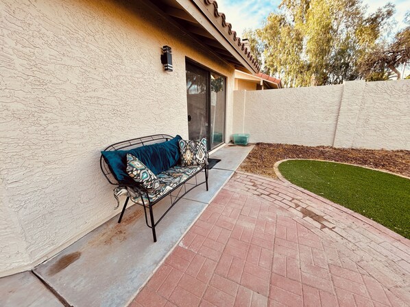 A patio with a metal bench and a small garden area. - Ahwatukee Gem: Pool ,Hot Tub, Mini-Golf, Bocce (Phoenix)