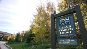 Señal para Grand Timber Lodge con indicaciones para el registro de huéspedes.