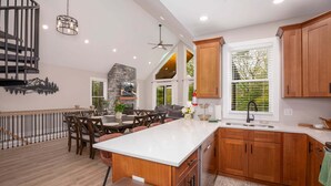 Una cocina amplia con armarios de madera, una isla grande y un comedor con sillas.