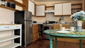 A modern kitchen with a stainless steel refrigerator, a stove, and wooden cabinets. - Rustic 1-bedroom studio in Emigrant near Yellowstone N.P. and Chico Hot Springs (Emigrant)