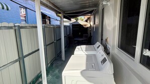 A laundry area with two washing machines, a window, and a covered walkway. - Family Home in the Heart of Miami (Miami)