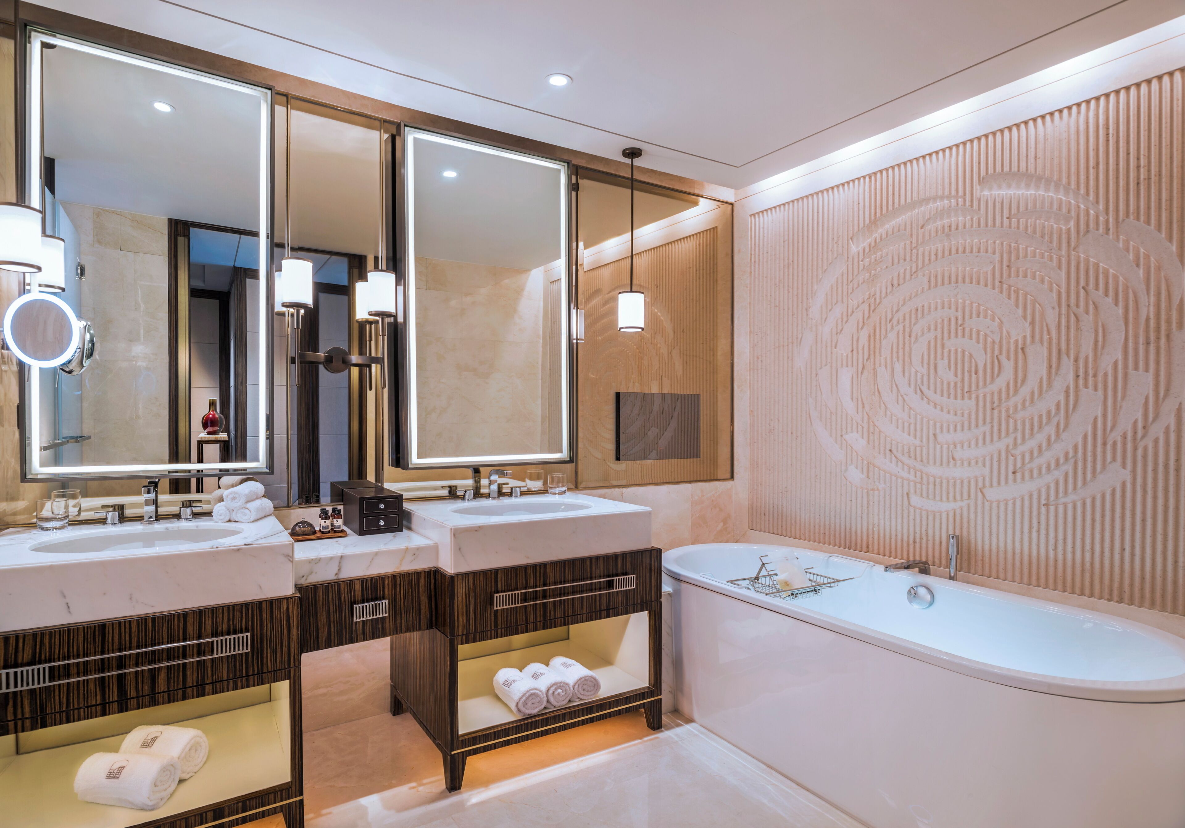 A modern bathroom with two sinks, a large mirror, a bathtub, and a wooden wall design.