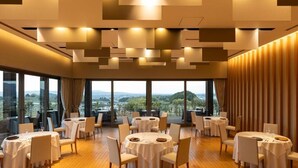 A dining area with round tables, chairs, and a view of the landscape through large windows. - AUBERGE de SENVIE (Sakurai)