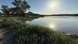 Ein ruhiger See mit Bäumen und wolkenlosem Himmel.