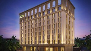 A multi-story hotel with a symmetrical facade, large windows, and a prominent 'GOLDFINCH' sign. - Goldfinch Panjim Goa (Panaji)