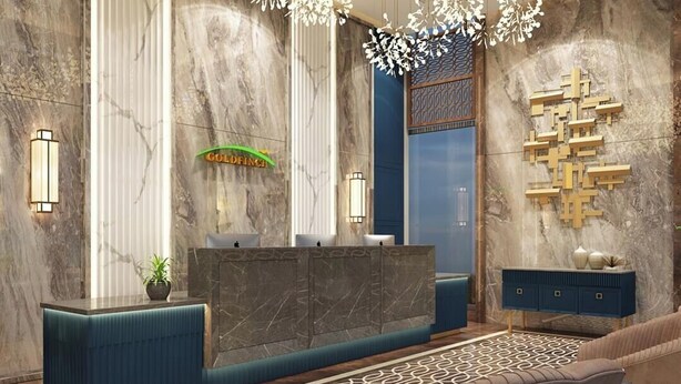 A modern lobby with a reception desk, a chandelier, marble walls, and a patterned rug. - Goldfinch Panjim Goa (Panaji)