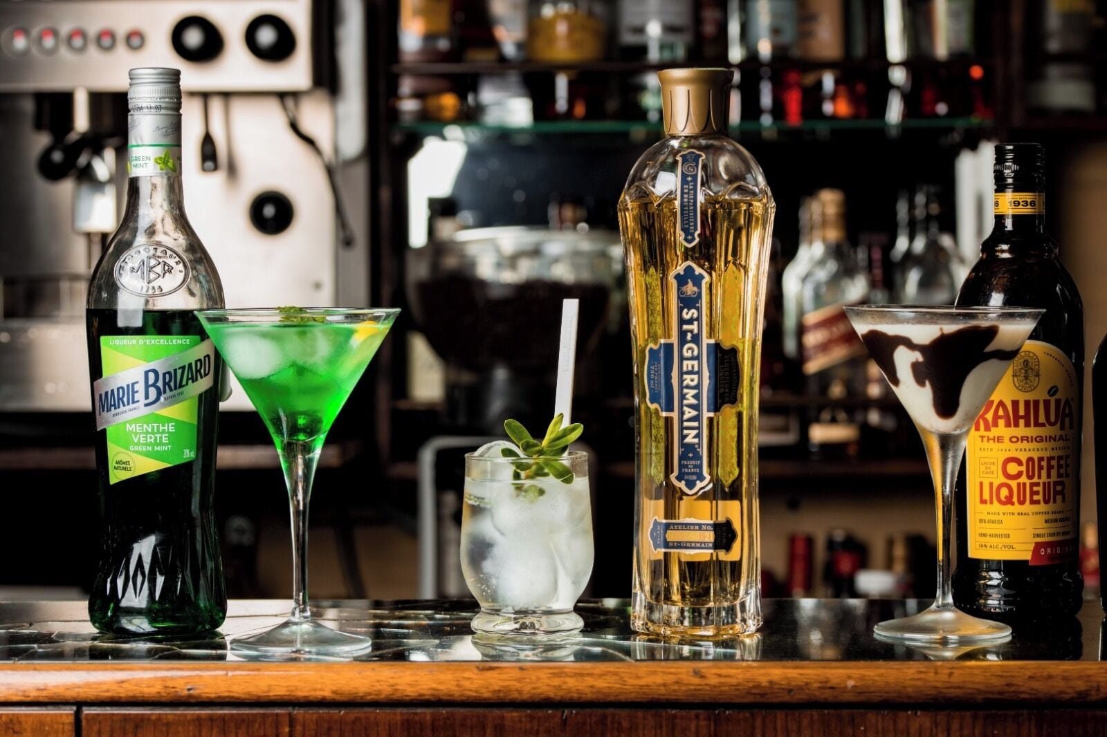 Un bar con varias botellas de licores, incluyendo Marie Brizard, St-Germain y Kahlúa.