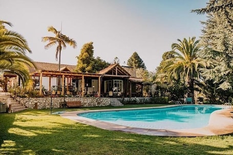 Una piscina al aire libre, tumbonas. Hotel Fundo Las Tórtolas