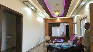 Una habitació amb un llit, una cadira, una taula petita i una decoració mural.