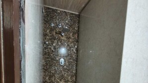Un angle d'una habitació amb una paret de marbre i una paret senzilla.