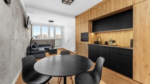Une cuisine moderne avec des meubles en bois, un plan de travail noir et un four encastré.