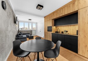 Eine moderne Küche mit Holzschränken, einer schwarzen Arbeitsplatte und einem eingebauten Backofen.
