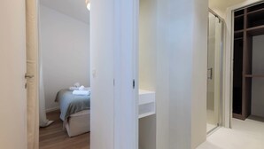 Une chambre d’hôtel comprenant un lit, une table de chevet, un miroir et une armoire.