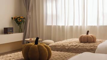 A bedroom with a bed, a small table, a lamp, and two decorative pumpkins.