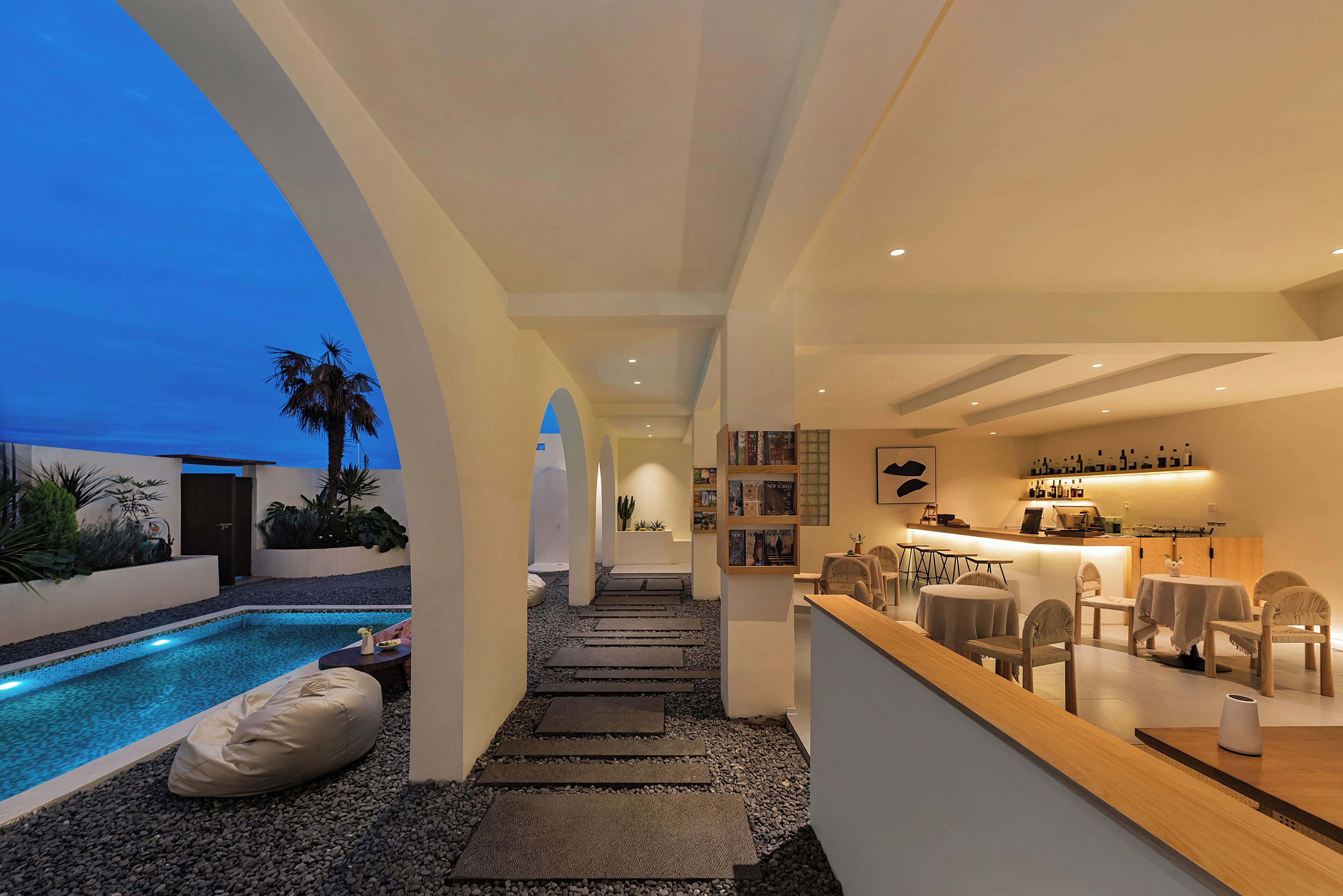 Eine moderne Bar mit Pool, Sitzgelegenheiten und einer Treppe zu einer weiteren Ebene.
