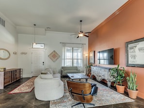 A living room with a sectional sofa, a wooden chair, a coffee table, and a fireplace. - Antique and Modern Charming 3-bedroom home, 7 mins to Paycom & Convention Center (Oklahoma City)