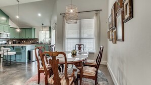 Un coin repas avec une table ronde, des chaises et un tapis à motifs.