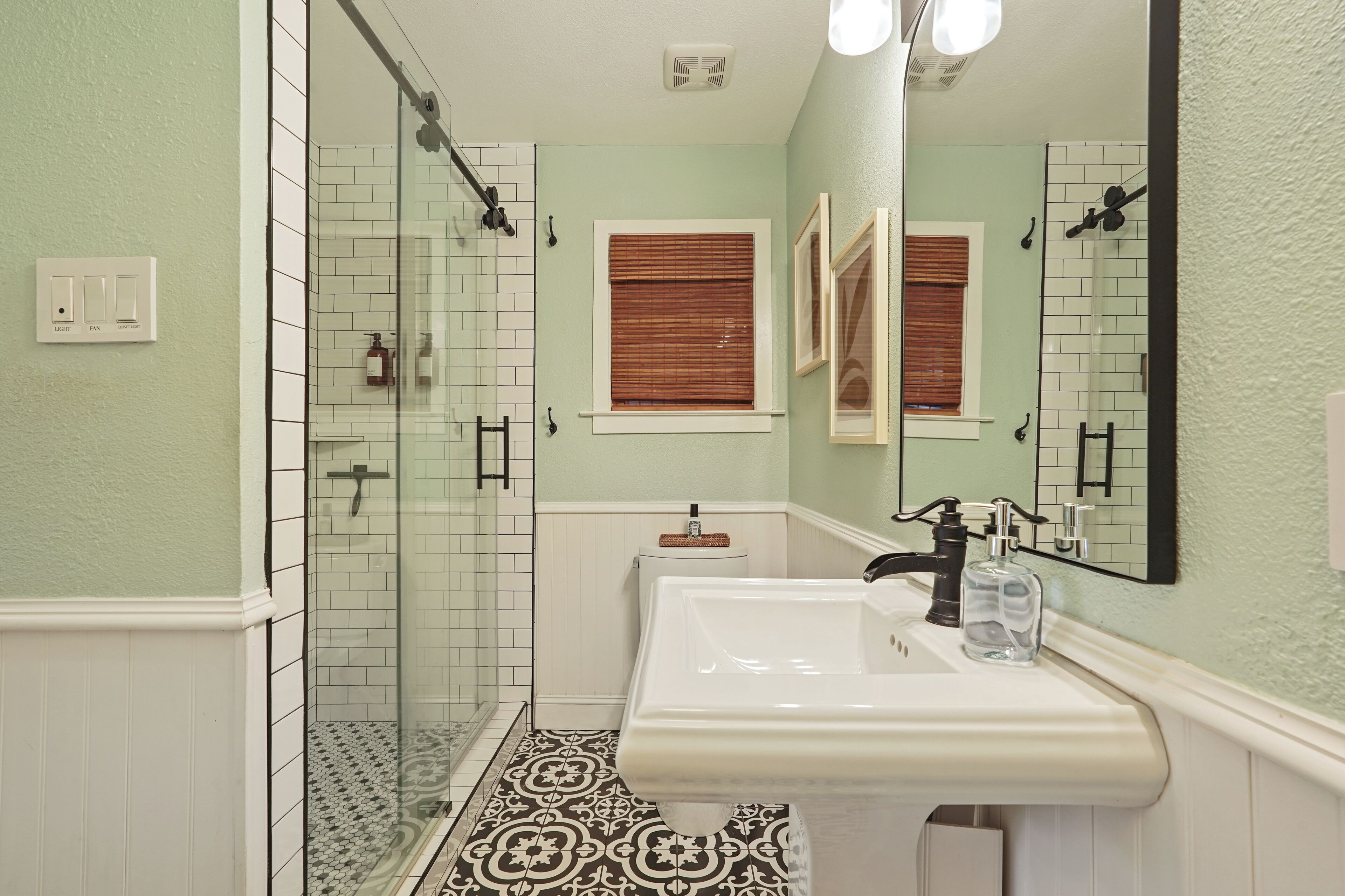 A bathroom with a shower, a sink, and a mirror.