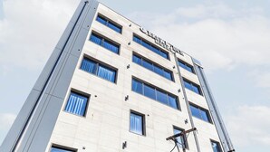 A tall hotel building with a modern design, featuring multiple windows and a prominent sign at the top. - Brown Dot Hotel Jinjuseong (Jinju)